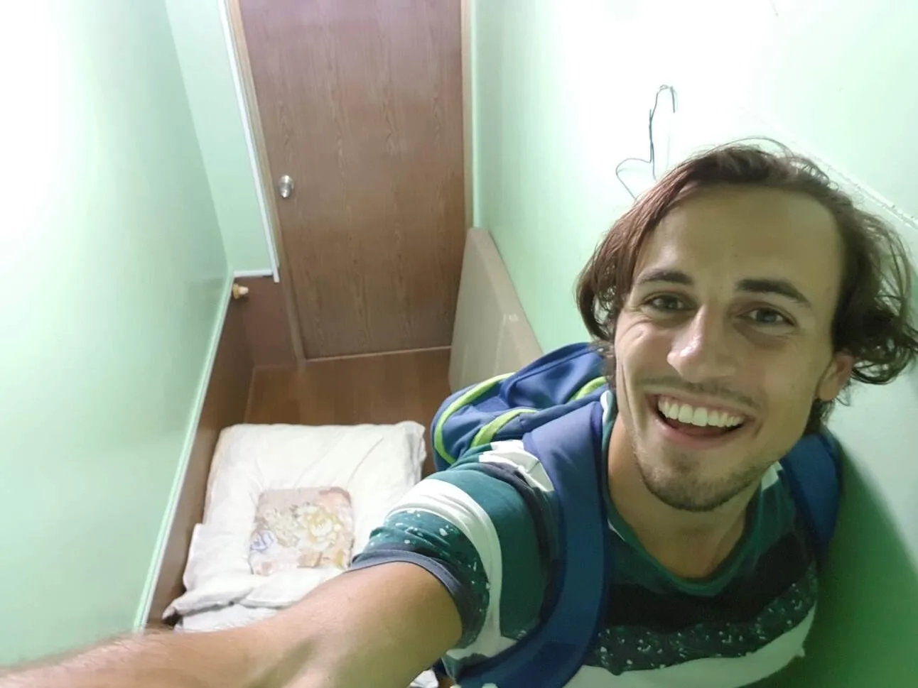 a selfie of a person in a small bedroomm